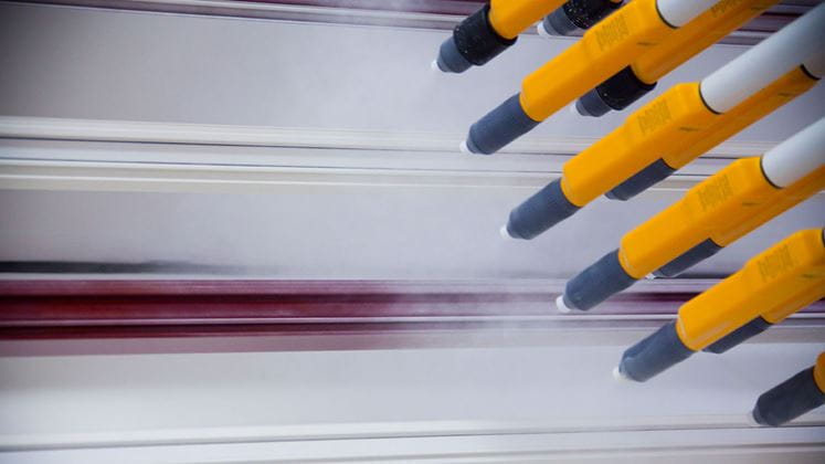 Aufsprühen des elektrisch geladenen Farbpulvers auf ein Fensterrahmenprofil